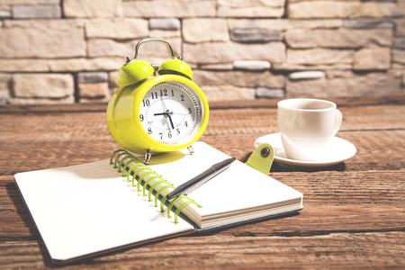 clock on notepad and coffee on deskの写真素材