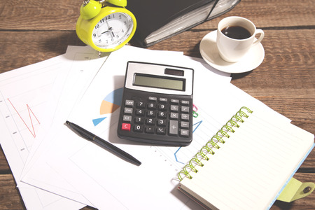calculator with document and clock on deskの写真素材
