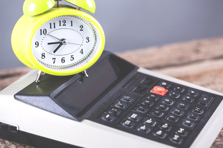 clock on calculator on wooden table backgroundの写真素材