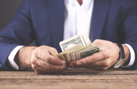 young business man hand money on tableの写真素材