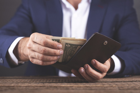 man hand money and wallet on table