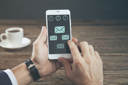 man hand  phone with messige sign in screen and coffee on tableの写真素材