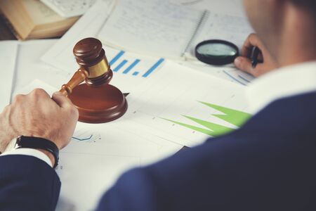 Business lawyer writing hard at office deskの写真素材