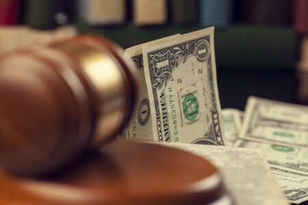wooden judge with money and book on table