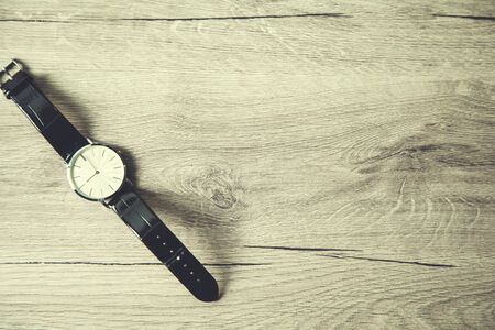 man elegant watch on wooden table backgroundの写真素材