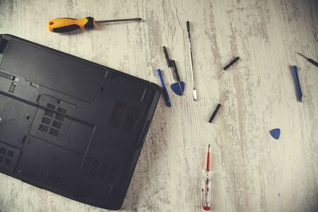 broken laptop with different  tools on tableの写真素材
