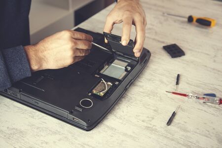 Man hand laptop disassembling in tool on table