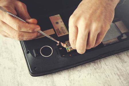 Man hand laptop disassembling in tool on table