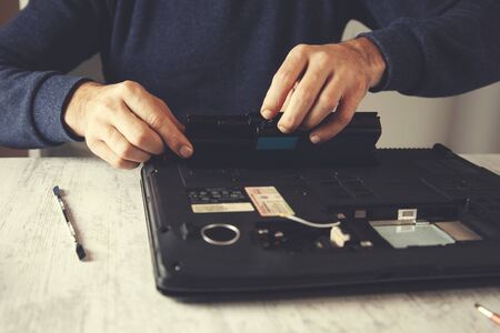 Man hand laptop disassembling in tool on tableの写真素材