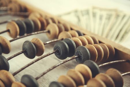 wooden abacus with money on the table background