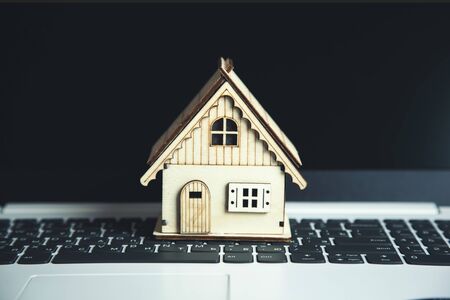 wooden house model on the computer keyboardの写真素材