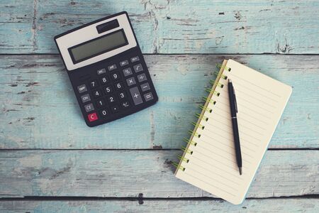 calculator with notepad on wooden table backgroundの写真素材