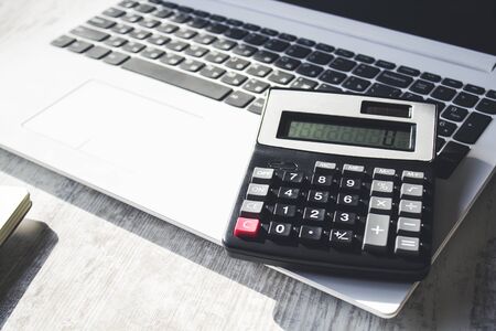 calculator on computer keyboard on wooden table