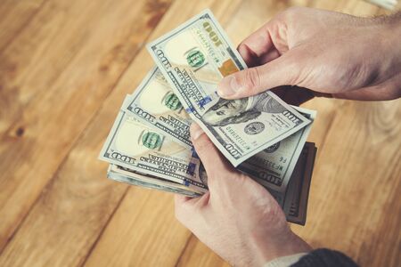 man hand  money on the wooden table background