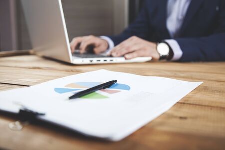 man working in computer with graph in officeの写真素材