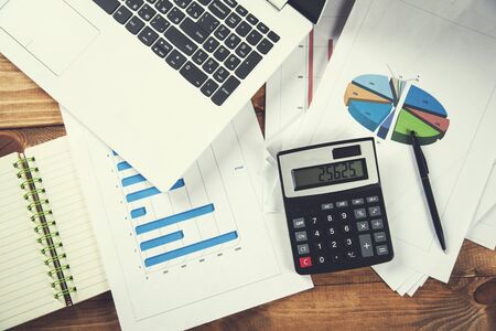 calculator with computer on graph on office deskの写真素材