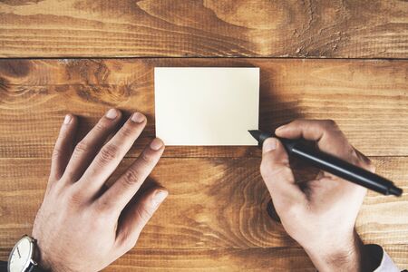 businessman showing card with pen on table
