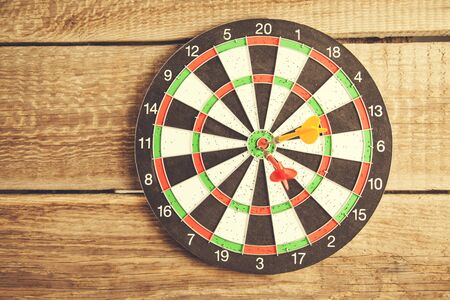 Arrows on target dart on wooden background