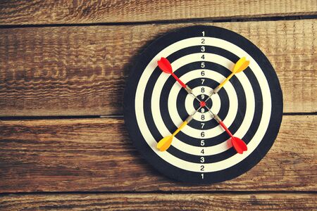 Arrows on target dart on wooden background