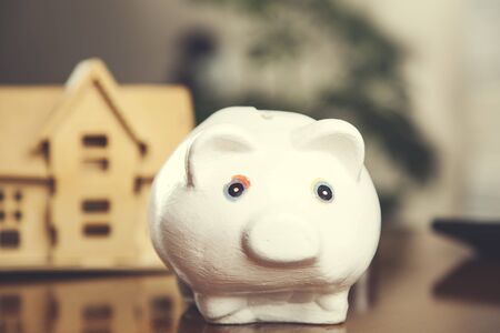 house model with piggy bank on deskの写真素材