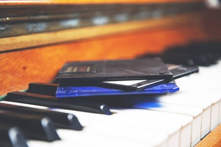 floppy disks on the piano keyboard backgroundの写真素材