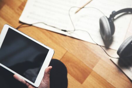 girl hand  tablet with music book in homeの写真素材