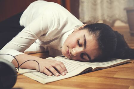 sleeping girl on music book with earphone 