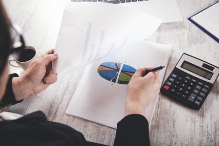 woman hand graph with calculator on desk