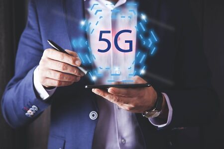 man hand holding  5G text on tabletscreenの写真素材