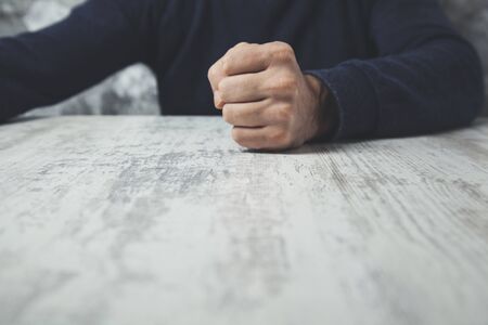 man hand fists on the wooden  tableの写真素材