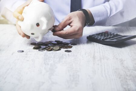 man hand coins with piggy bank and calculatorの写真素材