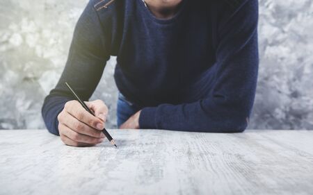 man hand pencil on  gray  table backgroundの写真素材