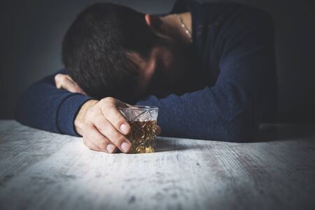 sad man hand  whiskey on the deskの写真素材