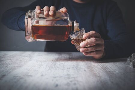 sad man hand whiskey bottle with glass