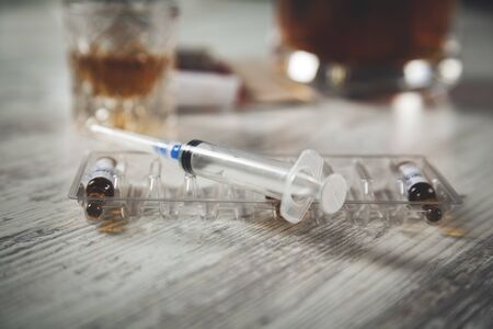 drug with syringe and whiskey  on the deskの写真素材