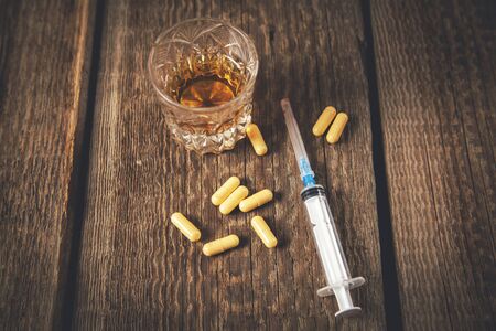 drug with syringe and whiskey  on the deskの写真素材