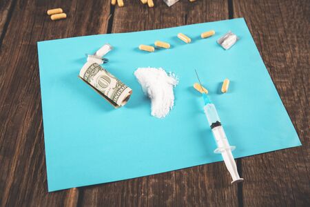 drug and syringe with narcotic on desk