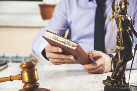 hand money and book with judge  on desk