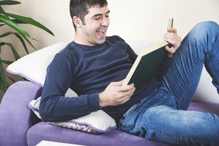happy  young man hand book in sofa