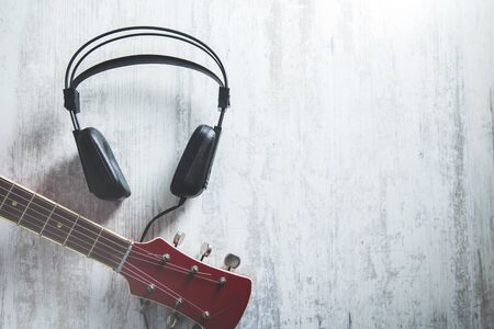 earphone with guitar on  the gray desk backgroundの写真素材
