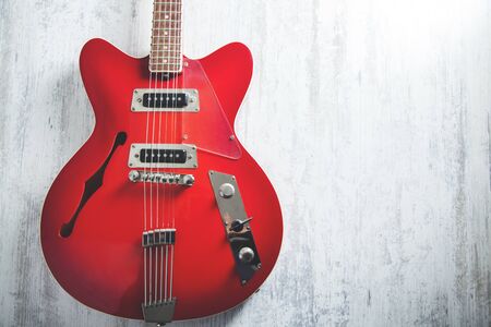 red guitar on the gray wooden desk background