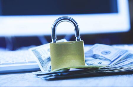 lock with money on keyboard on desk