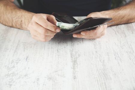 man hand money with wallet on deskの写真素材