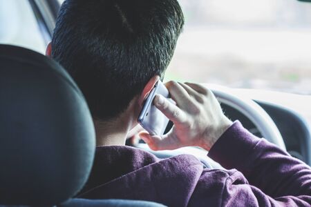 young man hand holding phone in car
