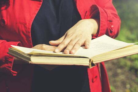 woman hand holding  book in green natureの写真素材