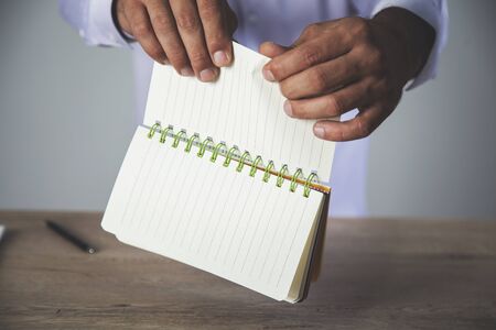 man tear notepad paper on  the desk