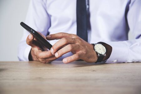 young man hand phone on the deskの写真素材