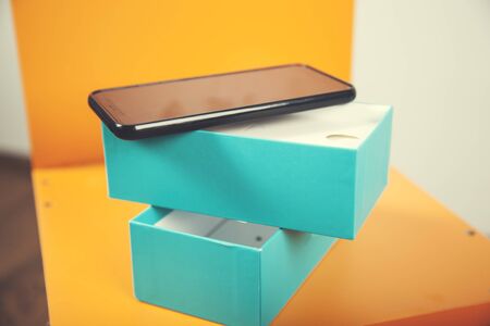 black smart phone on the box on orange background