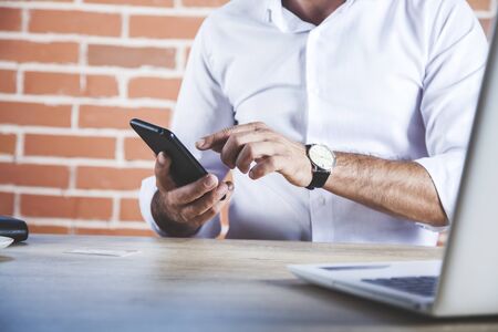 man hand phone with computer on the desk