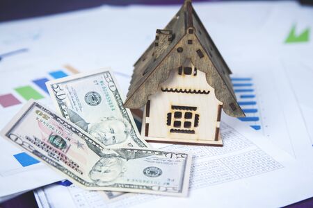 house model with money on graph on the desk